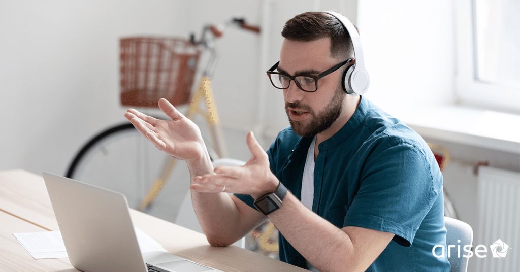 Smiling man wearing headset and working on a computer.