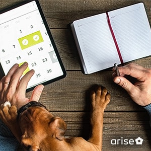 A tablet with a calendar app and a journal, with a man's hand holding a pen.