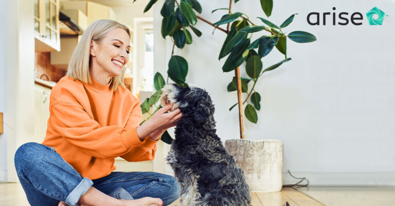 Woman sitting on the floor, petting her dog.