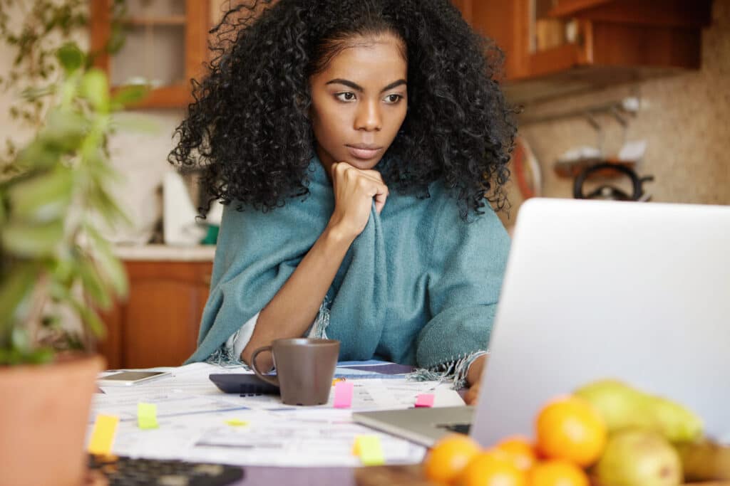 Serious looking woman working on a laptop.