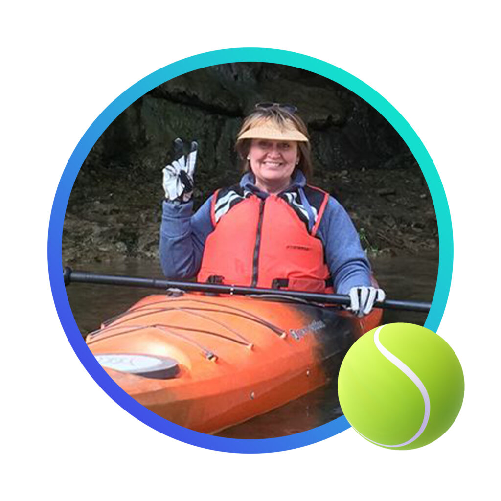 Smiling woman in a kayak and an image of a tennis ball in the lower right.