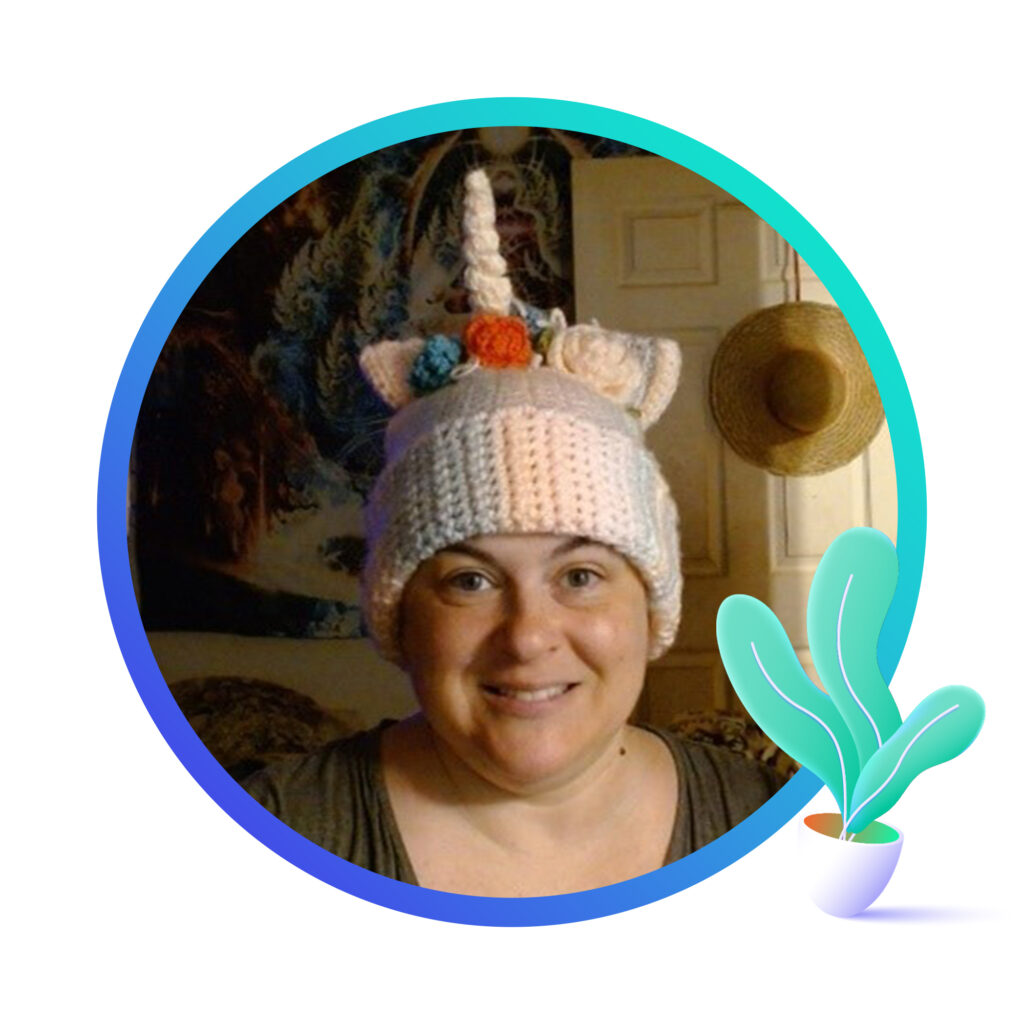 Smiling woman wearing a knitted unicorn hat and an image of a plant in the lower right.