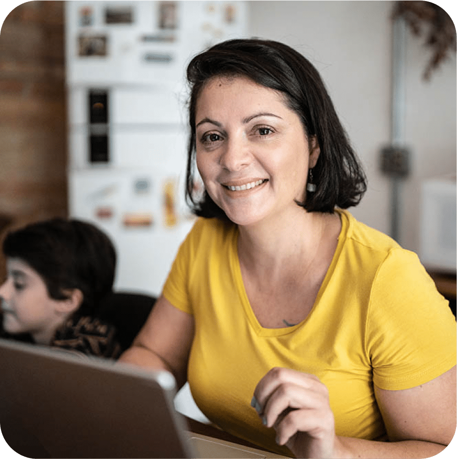 Smiling woman wearing a yellow shirt and a child sitting next to her.