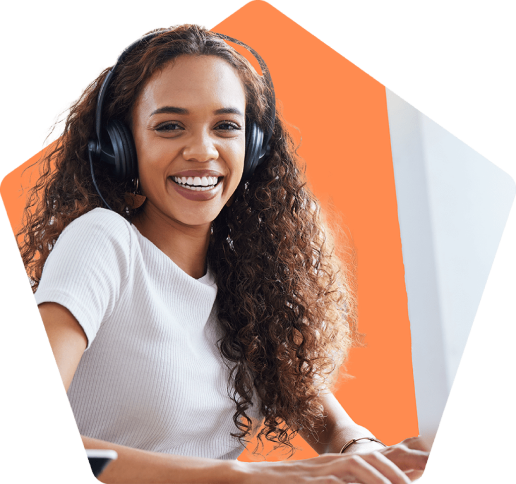 Smiling woman wearing headset and working on a computer.