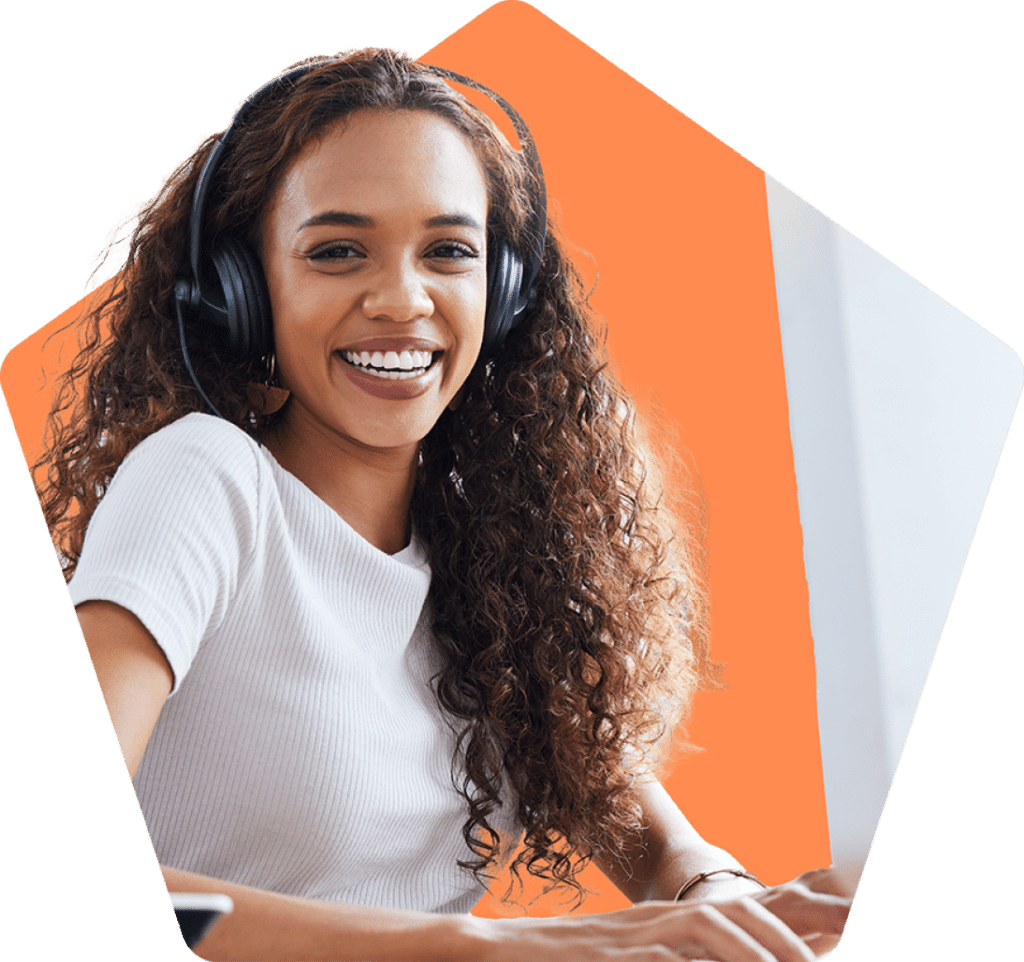 Smiling woman wearing headset and working on a computer.