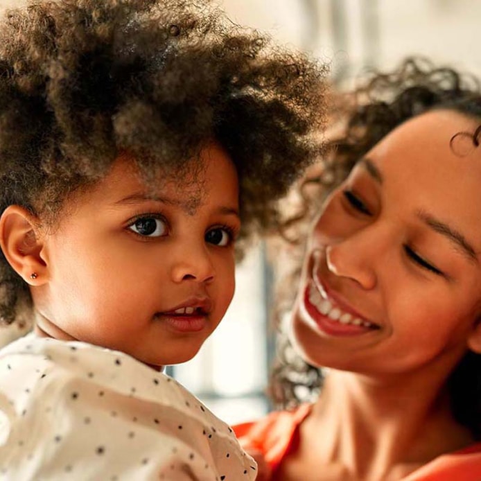 Smiling woman holding a child.