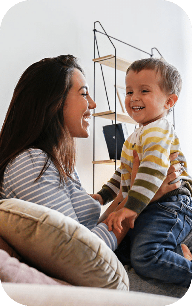 Smiling woman holding a smiling child.