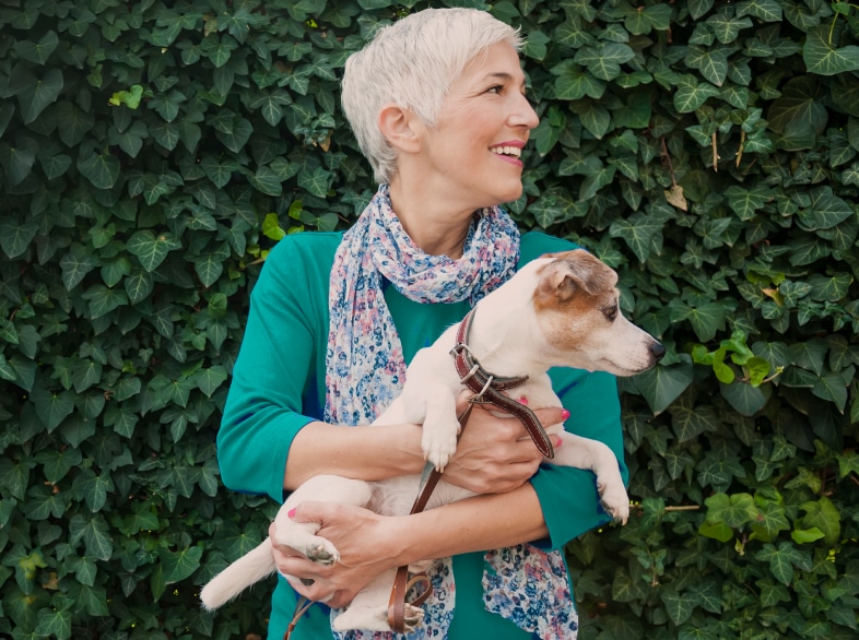 Smiling woman holding a dog.