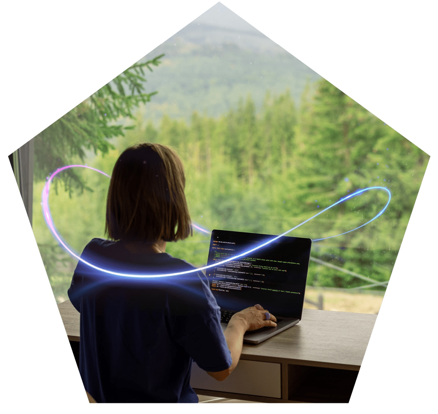 Woman working on a laptop in front of a window looking out at trees.