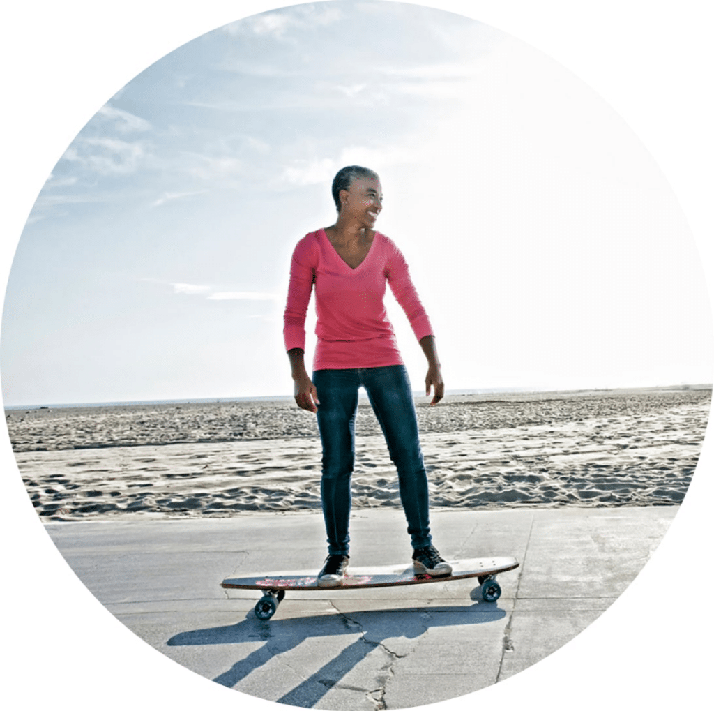 Smiling woman on a skateboard.