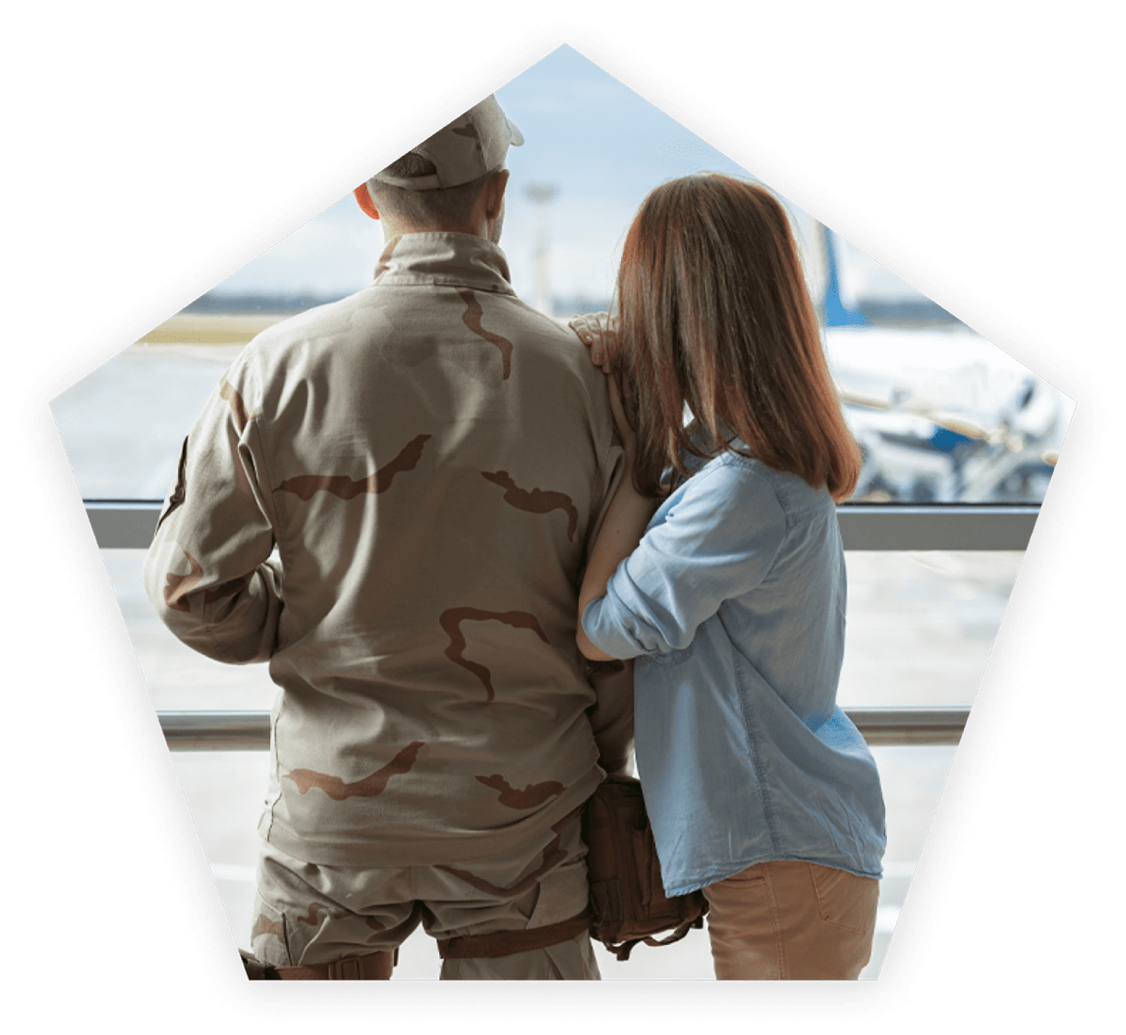 Military couple watches a plane being loaded.