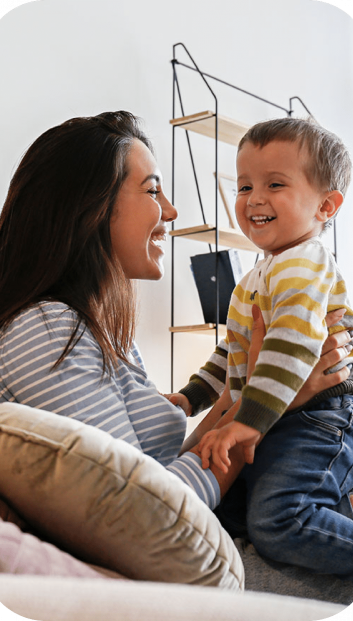 Smiling woman holding a smiling child.